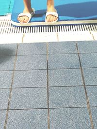 Low section of man standing on tiled floor