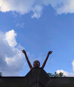 Low angle view of man against blue sky