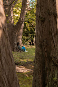 Attractive young woman reading book while sitting on grass in green public park. springtime outdoors