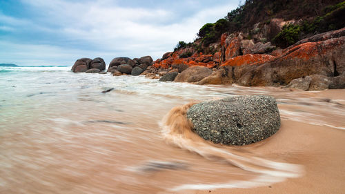 Surface level of rocks on shore against sky