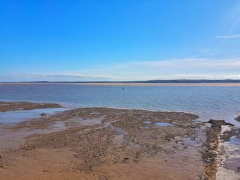 Scenic view of beach against blue sky