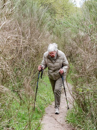 Man holding umbrella while standing on land in forest