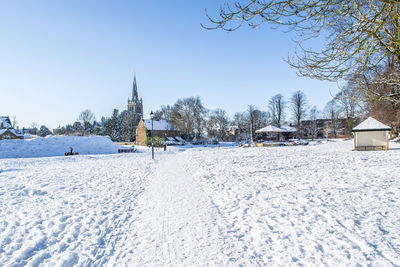 Panoramic view of snow covered buildings against clear sky