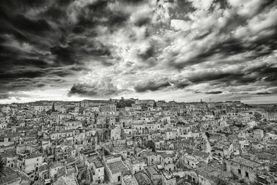 Aerial view of cityscape against cloudy sky