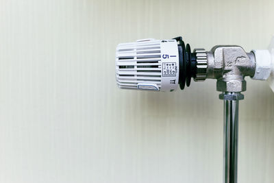 Close-up of coin-operated binoculars against white wall at home