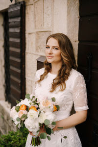 Portrait of smiling young woman holding bouquet