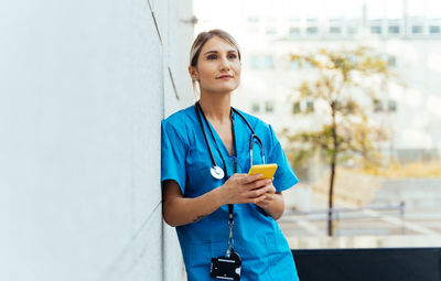 Portrait of young woman standing against sky