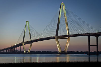 Suspension bridge over river against sky