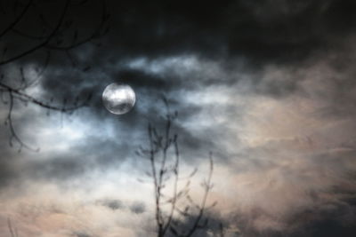 Low angle view of bare tree against cloudy sky