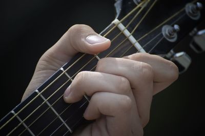 Cropped hand of person playing guitar