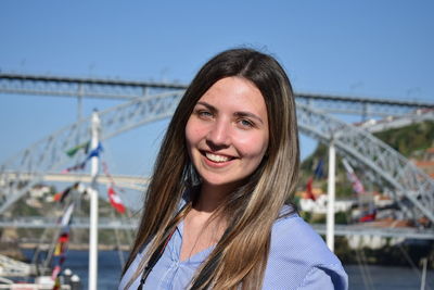 Portrait of smiling young woman against sky