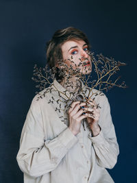 Portrait of woman drinking water against black background