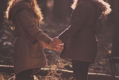 Side view of people holding hand of each other