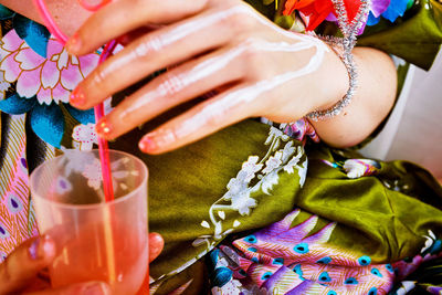 Midsection of woman with multi colored umbrellas