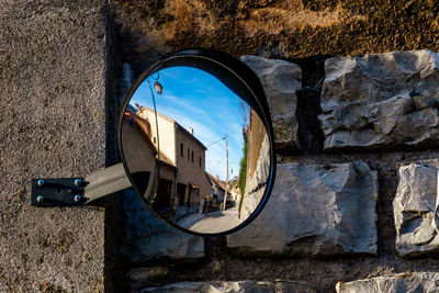 Reflection of building on mirror against wall