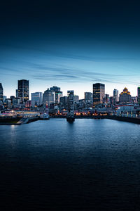 River and buildings in city at dusk