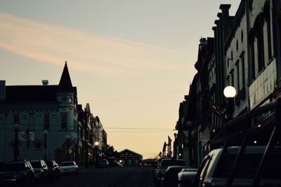 Cars on road in city against sky