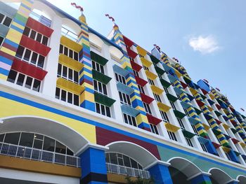 Low angle view of multi colored building against blue sky