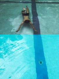 Low section of person swimming in pool
