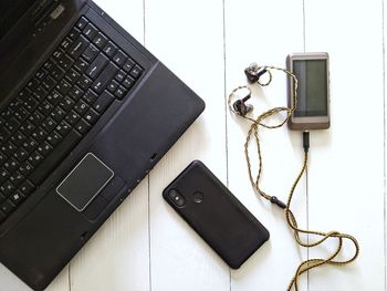 Laptop, music player with headphones, smartphone on white background