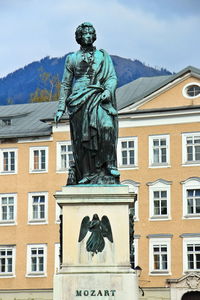 Low angle view of statue against building in city