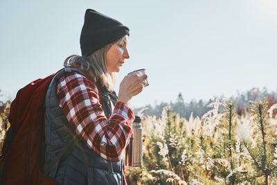 Woman taking break and relaxing with cup of coffee during summer trip. woman spending vacations