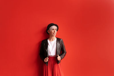 Portrait of a smiling young woman against red background