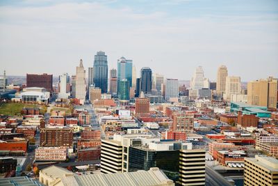 Aerial view of buildings in city against sky