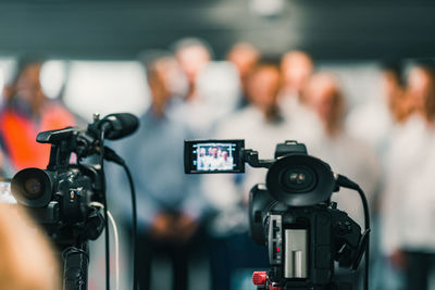 Close-up of camera against business people