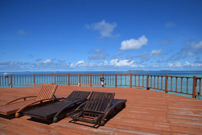 Chairs on beach against blue sky