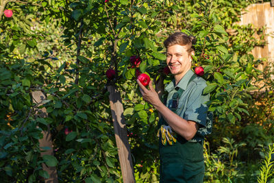 Portrait of young woman gardening in forest