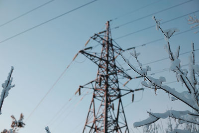 Low angle view of electricity pylon against sky