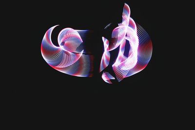 Close-up of illuminated lighting equipment against black background