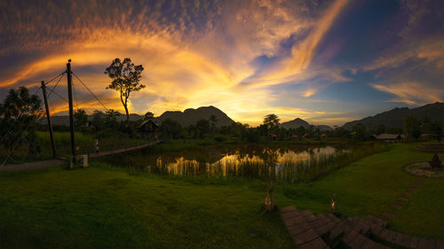 Scenic view of agricultural field against sky at sunset