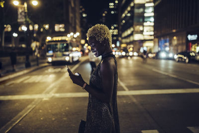 Side view of man using mobile phone on city street