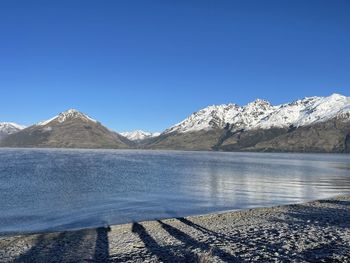 Scenic view of lake and mountains against clear blue sky in frankton queenstown