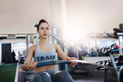 Portrait of young woman exercising in gym