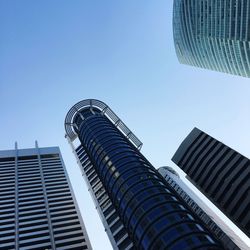 Low angle view of modern buildings against clear blue sky