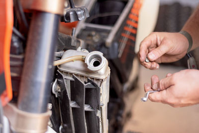 Cropped hands repairing motorcycle