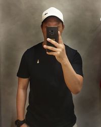 Midsection of man photographing with mobile phone