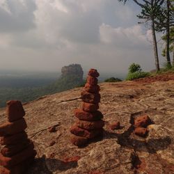 Stack of rock on landscape against sky
