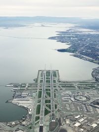 High angle view of cityscape by sea against sky