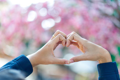 Cropped hands making heart shape