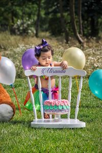 Cute girl with balloon balloons on field