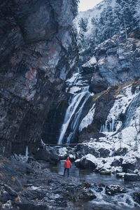 Person standing against waterfall