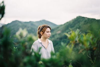 Portrait of young woman standing on rock