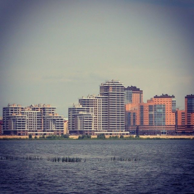 building exterior, architecture, built structure, waterfront, water, city, rippled, sea, river, clear sky, sky, building, copy space, residential building, mid distance, residential structure, cityscape, outdoors, no people, day