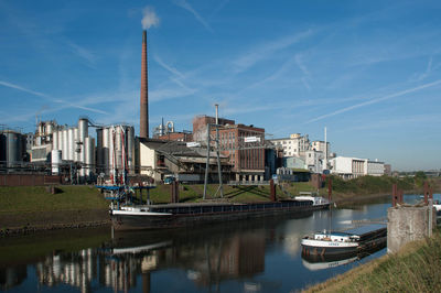 Boats in canal near factory building