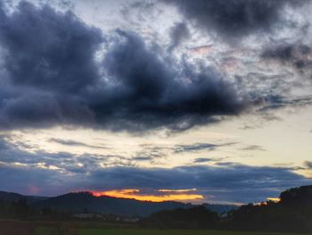 Scenic view of dramatic sky over silhouette landscape