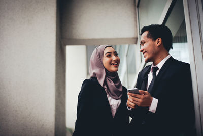 Business people discussing while standing by glass window